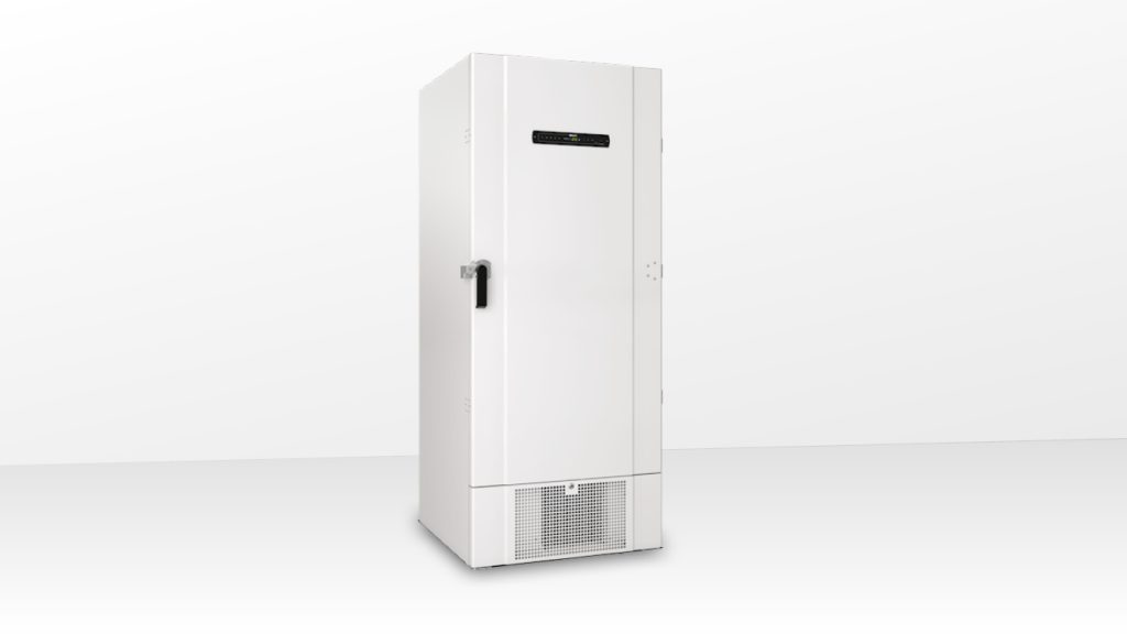 Ein weißer aufrechter Tiefkühlschrank steht isoliert vor einem einfarbigen Hintergrund.