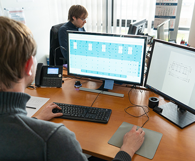 Ein Büroangestellter arbeitet an einem Doppelmonitor-Computerarbeitsplatz.